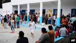 Pemilih mengantri di luar tempat pemungutan suara selama putaran pertama pemilihan presiden, di La Marsa, di luar Tunis, Tunisia, 15 September 2019. (Foto: AFP)