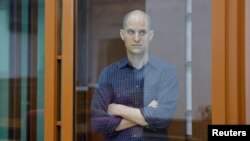 FILE - Wall Street Journal reporter Evan Gershkovich, who stands trial on spying charges, is seen inside an enclosure for defendants before a court hearing in Yekaterinburg, Russia, June 26, 2024. 
