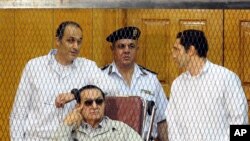 Mantan Presiden Hosni Mubarak bersama kedua putranya, Gamal Mubarak (kiri) dan Alaa Mubarak saat hadir di sidang pengadilan di Kairo (foto: dok).