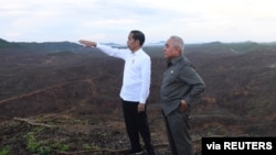 FILE - Indonesian President Joko Widodo and Governor of East Kalimantan Isran Noor visit an area planned to be the location of Indonesia's new capital, at Sepaku district in East Kalimantan province, Indonesia, Dec. 17, 2019