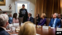 Ông Elon Musk đã tham dự cuộc họp nội các đầu tiên của Tổng thống Donald Trump ngày 26/2/2025, đội mũ bóng chày màu đen, nhưng không ngồi cùng bàn với ông Trump và các quan chức nội các.