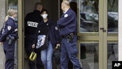 French police officers stand guard at the entrance of a building in Strasbourg, France, Saturday Oct. 6, 2012, where a suspect was shot dead after firing at police.