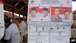 Poster bergambar kedua kandidat presiden dan wakil presiden di sebuah tempat pemungutan suara di Bali (9/7). (AP/Firdia Lisnawati)