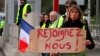 A demonstrator holds a placard reading "Join us" as protesters stand by toll gates on a motorway at Biarritz southwestern France, Dec. 5, 2018. 