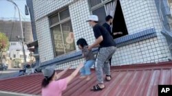 Stanovnici spasavaju dijete iz djelimično srušene zgrade u Hualijenu (Foto:AP/TVBS)