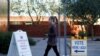 A woman walks to cast her ballot at the register of voters during early voting in Phoenix, Arizona, October 29, 2020.