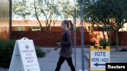 A woman walks to cast her ballot at the register of voters during early voting in Phoenix, Arizona, October 29, 2020.