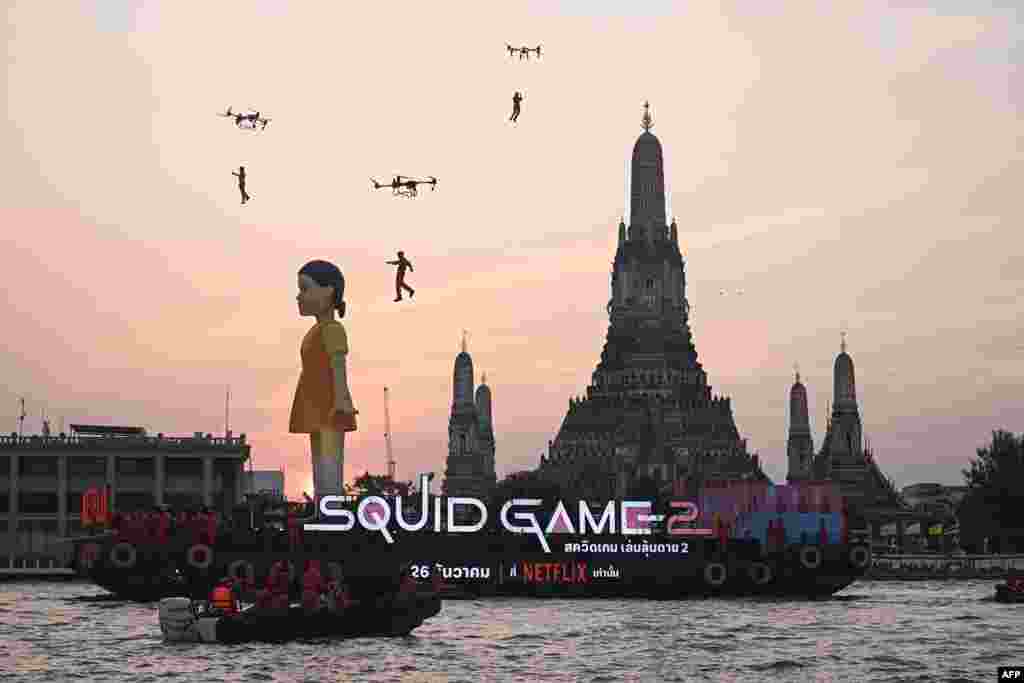 A 12-meter-tall statue of Young-hee, the iconic doll from Netflix&#39;s South Korean TV series Squid Game&nbsp;is seen on a barge in front of Wat Arun temple on the Chao Prayer River ahead of the launch of Season 2, in Bangkok, Thailand.