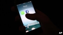 FILE - This Feb. 19, 2014 photo shows the Facebook app icon on an iPhone in New York. Facebook is rolling out a iPhone app that will interpret what's in a photo using a form of artificial intelligence to recognize faces and objects for blind and visually impaired. 