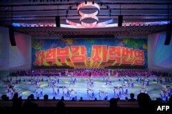 지난해 1월 북한 평양체육관에서 열린 노동당 8차 대회 기념 공연에 '자력부강·자력번영' 표어가 게시되고 있다. (자료사진)