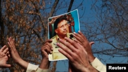 Seorang demonstran memegang foto mantan Presiden Pakistan Pervez Musharraf, dalam aksi protes di luar pengadilan untuk memberi dukungan kepada mantan penguasa militer yang tengah disidang di Islamabad (18/2).