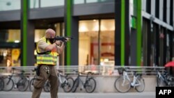Un policier, arme déployée, assure la sécurité au centre commercial (l'Olympia Einkaufzentrum (OEZ)) où a eu lieu une fusillade, à Munich, Allemagne, 22 juillet 2016. 