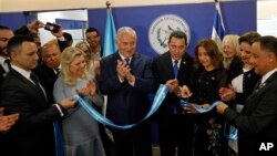 Israeli Prime Minister Benjamin Netanyahu, third left, his wife, Sara, second left, and Guatemalan President Jimmy Morales, center, watch as the Guatemalan first lady Hilda Patricia Marroquin cuts the ribbon during the dedication ceremony of the embassy o
