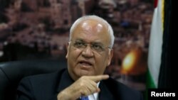 Kepala negosiator Palestina Saeb Erekat memberi isyarat saat konferensi pers di Ramallah di Tepi Barat, 24 Juni 2018. (Foto: REUTERS/Mohamad Torokman)