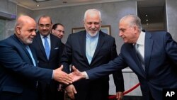 Menlu Irak, Mohamed Alhakim, kanan, berjabat tangan dengan Dubes Iran di Irak, Iraj Masjedi, kiri, dalam kunjungan Menlu Iran, Mohammad Javad Zarif, tengah, di Kemenlu Irak di Baghdad, Irak, Minggu, 10 Maret 2019 (foto: AP Photo/Hadi Mizban)