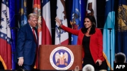 资料照片：前美国众议员加巴德在密歇根州底特律的国民警卫队协会大会上宣布支持共和党总统候选人特朗普后向人群挥手。(2024年11月13日)