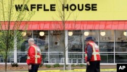 Emergency workers walk outside a Waffle House restaurant Sunday, April 22, 2018, in Nashville, Tennessee. At least four people died after a gunman opened fire at the restaurant early Sunday.
