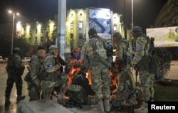 Para militan oposisi Suriah berkumpul di sekitar api unggun di Lapangan Saadallah al-Jabiri, setelah pemberontak mengklaim telah mencapai jantung Aleppo, Suriah, 30 November 2024. (Foto: Reuters)