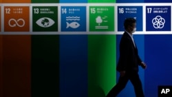 A man wearing a face mask to help curb the spread of the coronavirus walks in a business district May 7, 2020, in Tokyo. 