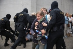 Law enforcement officers scuffle with demonstrators during a rally in support of detained Belarusian opposition leader Maria Kolesnikova in Minsk, Belarus, Sept. 8, 2020.