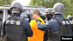 FILE - Officers of the National Intelligence and Security police arrest an alleged drug trafficker in San Jose, Costa Rica, Nov. 22, 2016, in this pixelated handout provided by the Ministry of Public Security. 