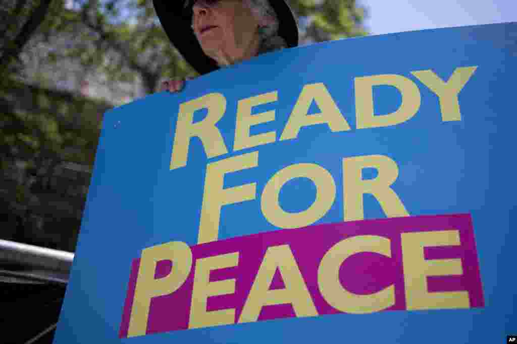 An activist holds a banner as U.S. President Donald Trump arrives in Jerusalem, Monday, May 22, 2017.
