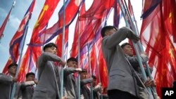 지난해 4월 평양 김일성 광장에서 열린 대규모 열병식에서 인공기를 든 주민들이 행진하고 있다. (자료사진)