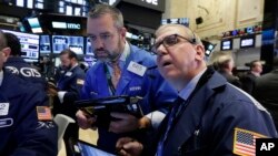 FILE - Traders Kevin Lodewick, left, and Richard Cohen work on the floor of the New York Stock Exchange, Sept. 26, 2016.