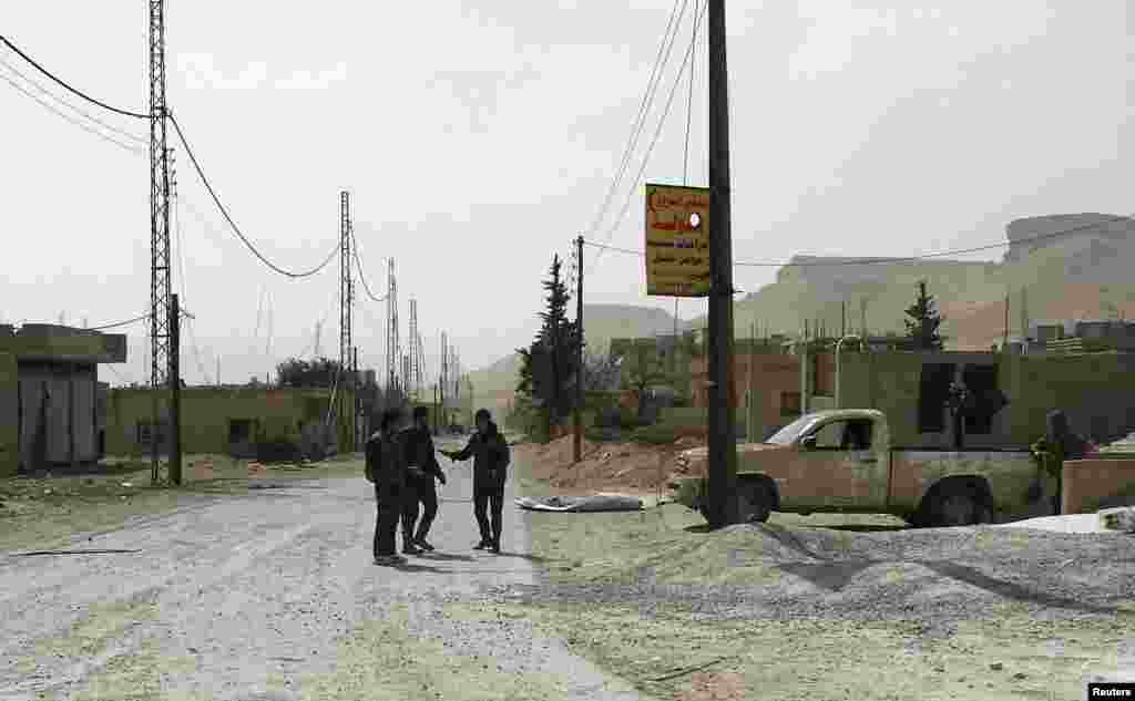 Forces loyal to Syria's President Bashar al-Assad stand near a road in Al-Sahl town, north of Yabroud, March 4, 2014.