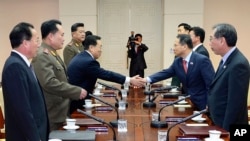 Ketua delegasi Korea Selatan Kim Kyou-hyun (dua dari kanan) berjabat tangan dengan ketua delegasi Korea Utara Won Tong Yon (tiga dari kiri) dalam pertemuan di desa perbatasan Panmunjom, Korea Selatan (12/2). 