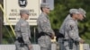 Soldiers stand guard on the driveway leading to the courthouse holding the the court martial of Maj. Nidal Malik Hasan in Fort Hood, Texas, August 23, 2013. 