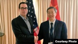 2018年10月10日，美国财政部长姆努钦和中国人民银行行长易刚在国际会议期间握手，姆努钦说双方讨论了重要经济问题（姆努钦推特图片）。