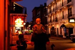 In the aftermath of Hurricane Ida, a family walks down Bourbon Street, Sept. 4, 2021, in the French Quarter of New Orleans.