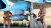 FILE - In this photo taken on Saturday, Oct. 3, 2015, Russian military support crew attach a satellite guided bomb to SU-34 jet fighter at Hmeimim airbase in Syria. 