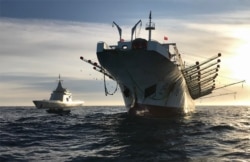 FILE - A handout picture released by Argentina's Navy press office shows the ARA “Bouchard” Ocean Patrol escorting a Chinese-flagged fishing ship after it was caught illegally operating in Argentina's Exclusive Economic Zone, May 4, 2020.