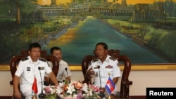 Tea Vinh, commander of the Royal Cambodian Navy (R), welcomes Yu Manjiang, commanding officer of the Chinese fleet visiting Cambodia, in Phnom Penh, Feb. 24, 2016.