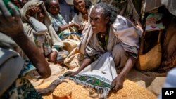 រូបឯកសារ៖ ស្ត្រី​ម្នាក់​ឈ្លោះ​ប្រកែក​គ្នា​ជាមួយ​នឹង​អ្នក​ផ្សេង​ទៀត​រឿង​ចែក​ស្បៀង​អាហារ​ដោយ​អង្គការ​មនុស្សធម៌ Relief Society of Tigray ក្នុង​ក្រុង Agula តំបន់Tigray ប៉ែក​ខាង​ជើង​ប្រទេស​អេត្យូពី ថ្ងៃទី៨ ខែឧសភា ឆ្នាំ២០២១។ (AP Photo/Ben Curtis)