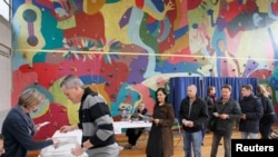 Orang-orang mengantri untuk memberikan suara mereka pada putaran kedua pilpres Perancis 2017 di TPS di Bron, Perancis, 7 Mei 2017. 