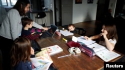 រូបឯកសារ៖ អ្នកស្រី Marina Brebion ដែល​ជា​គ្រូ​បង្រៀន​កំពុង​ជួយ​ដល់​កូនៗ​​ធ្វើ​លំហាត់​នៅផ្ទះ ក្នុង​ពេល​ដែល​ប្រទេស​បារាំង​កំពុង​បិទ​ប្រទេស ដើម្បី​ទប់ស្កាត់​ការ​ឆ្លង​កូវីដ១៩។