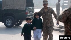 Vojnik ispraća decu iz vojne škole u Pešavaru, koju su napali pripadnici Talibana