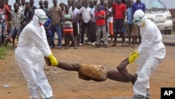 Petugas kesehatan membawa seorang penderita ebola dan memasukkan ke kantung plastik di Monrovia, Liberia (foto: dok).