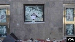 "Anything but the messenger of God," reads a sign left in the shattered window of a U.S. compound after it was stormed by rioters in Sana'a, Yemen, Sept. 13, 2012. (C. Coombs for VOA)