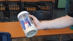 Eric Foley, CEO of Voice of the Martyrs Korea, displays a bottle filled with rice, vitamins, and a Bible, which he was prepared to send to North Korea, in Seoul, South Korea. June 5, 2020. (William Gallo/VOA)