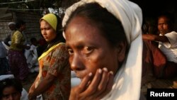 FILE - Rohingya people wait to receive their share of food aid from the World Food Program (WFP) at the Thae Chaung camp for internally displaced people in Sittwe, Rakhine state.