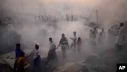 Pengungsi Rohingya berusaha menyelamatkan harta benda mereka setelah kebakaran besar di kamp Balukhali mereka di Ukhiya di distrik Cox's Bazar, Bangladesh, Minggu, 5 Maret 2023. (Foto: AP)