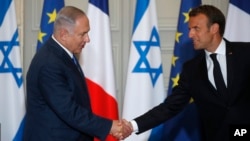 French President Emmanuel Macron and Israel's Prime Minister Benjamin Netanyahu shake hands as they attend a joint press conference at the Elysee Palace in Paris, June 5, 2018.