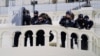 Policajci na položajima motre na demonstrante koji pokušavaju da se probiju kroz policijsku barijeru, 6. januara 2021, na Kapitol hilu, Vašington. (Foto: AP)