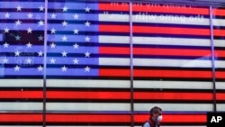 A man wearing a protective mask walks through Times Square, April 22, 2020, in New York. 