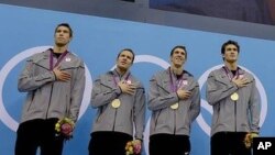 Michael Phelps (ketiga dari kiri) dan rekan setimnya berdiri di podium dalam penerimaan medali nomor 4X100 meter estafet putera (4/8). 