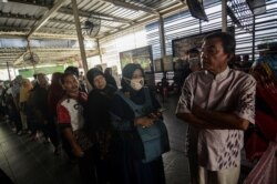 Passengers queue to refund their tickets during a major power blackout at a commuter train station in Jakarta, Indonesia, Aug. 4, 2019. (Antara Foto/Fakhri Hermansyah)